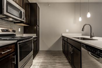 An empty kitchen with stainless steel appliances and a sink